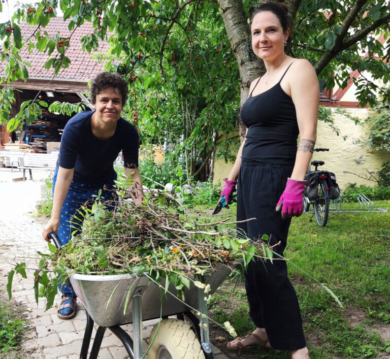 Mitarbeit als Betreuer in der Wohngruppe. Zwei Menschen betreiben Schneidearbeit von Hecken im Garten