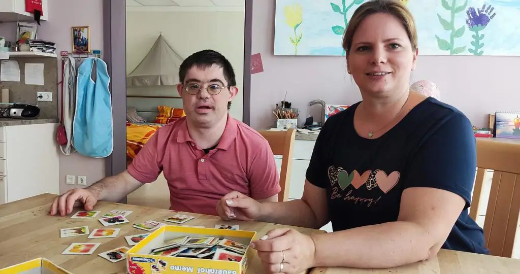 Mitarbeiterin und Bewohner spielen Memory