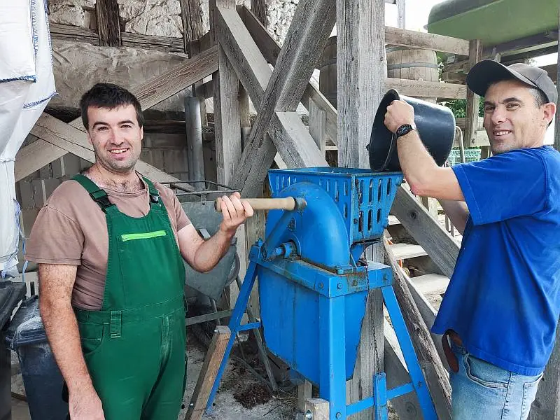 Landwirtschaft - Zwei Bewohner die manuell Körner verarbeiten
