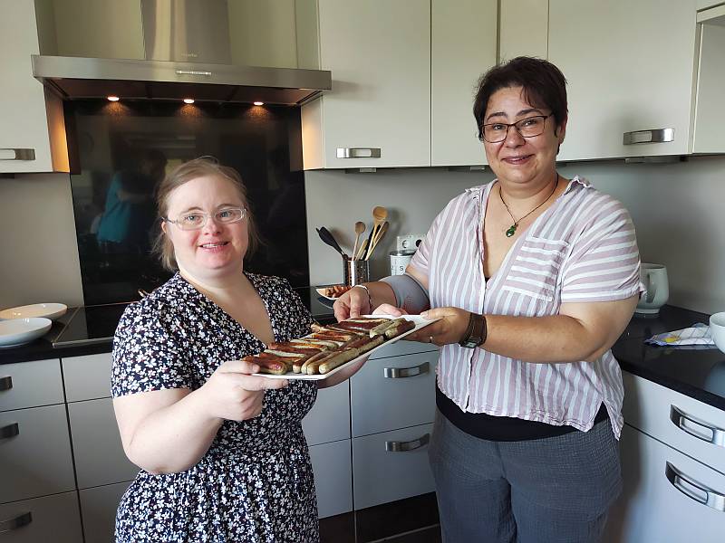 In jedem Haus wird noch selbst gekocht. Mitarbeiterin und Bewohnerin präsentieren stolz ihre Bratwürstchen