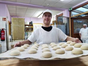Ein Bewohner präsentiert stolz die Backwaren der Bäckerei