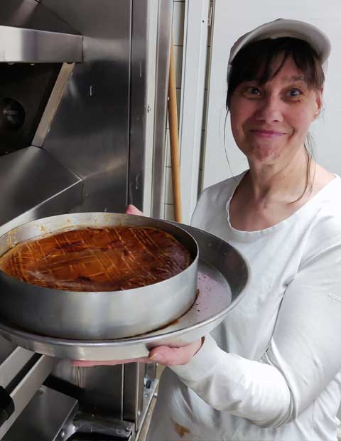 Stolz präsentiert die Bäckerin ihren Kuchen